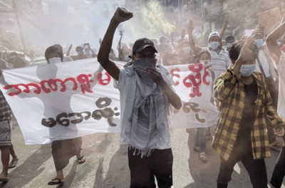 2021年7月3日，缅甸首都仰光市中心发生反军事政变抗议，示威者手持海报和照明弹游行。©欧新社-埃菲通讯社