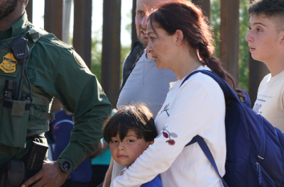 عائلة من المهاجرين تضمّ طفلاً بين أفرادها تُحمَّل في شاحنة حرس الحدود في 26 أيار/ مايو 2022 في إيغل باس تكساس بالولايات المتحدة الأميركية. © جون لامبارسكي/ نورفوتو