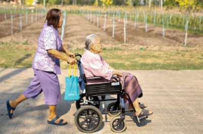 Sampao Jantharun (78 ans) et Somjit Phuthasiri (90 ans), en fauteuil roulant, se dirigent vers leur domicile au Wellness Nursing Home Center, à Ayutthaya, en Thaïlande, le 9 avril 2016. De nombreuses familles thaïlandaises s’occupent de parents âgés, ce qui représente un coût qui, à l’échelle nationale, s’élève à presque un tiers du revenu des ménages. Le nombre de familles confrontées à ce problème est appelé à augmenter, la population vieillissant à un rythme parmi les plus rapides d’Asie du Sud-Est. © Re