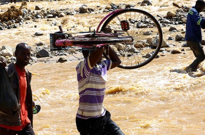2023年3月18日，距马拉维布兰太尔约100公里处，热带气旋弗雷迪过后，当地人穿过与莫桑比克接壤的穆洛扎的洪水灾区。© 路透社／Esa Alexander