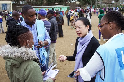 Le jour des élections, des membres de l’équipe de l’initiative Surge du HCDH discutent avec Maryanne Kasina, défenseuse des droits humains, dans un bureau de vote à Nairobi. © HCDH Photo/Stephen Kibunja