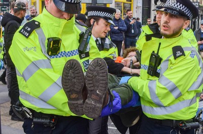警务人员在一次示威活动中逮捕了一名抗议者。“停止石油”（Just Stop Oil）组织的成员将自己的双手粘在金属管里，封锁了伦敦金融城市长官邸站附近的街道。图片来源：Vuk Valcic/SOPA Images/Sipa USA