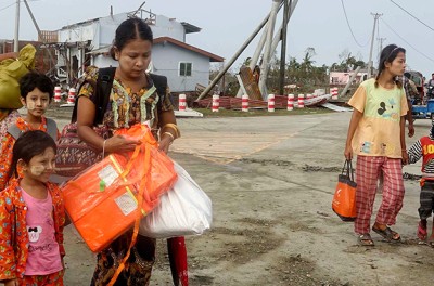Des personnes transportant leurs biens parmi les débris après le passage du cyclone Mocha à Sittwe, dans l’État rakhine, au Myanmar, le 15 mai 2023. EPA-EFE/NYUNT