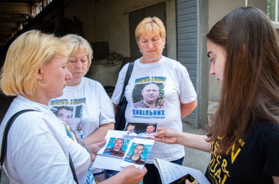 La Sra. Manukhina, cuyo hijo y marido fueron detenidos por soldados rusos, muestra fotografías de sus seres queridos. © ACNUDH/Yevhen Nosenko