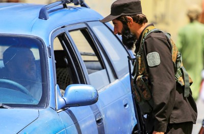 Des Taliban contrôlent une voiture à un poste de contrôle à Kaboul, en Afghanistan, le 18 août 2023. © EPA-EFE/SAMIULLAH POPAL
