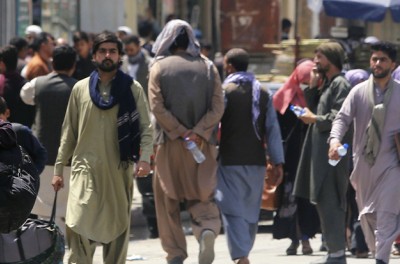 Des personnes se dirigent vers une installation militaire dans un aéroport de Kaboul, le 23 août 2021, après le récent retour au pouvoir du groupe militant islamique des Taliban. © (Kyodo)