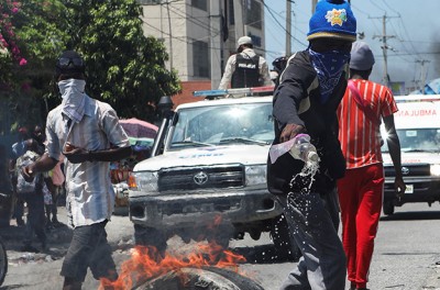 متظاهر يصب الوقود السائل على الإطارات لحرقها أمام حاجز خلال احتجاج على انعدام الأمن والمطالبة باستقالة رئيس وزراء هايتي أرييل هنري، في بورت-أو-برنس، هايتي، 17 أيلول/ سبتمبر 2023 Ⓒ رويترز/ رالف تيدي إيرول