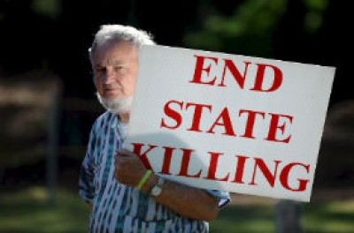 一名男子举着要求停止国家杀人行为的牌子 © EPA/ERIK S. LESSER