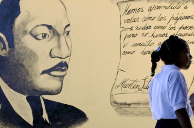 A Venezuelan schoolgirl stands in front of a mural with an image of U.S. civil rights activist, Martin Luther King, January 9, 2004. ©REUTERS/Jorge Silva JS/GAC.