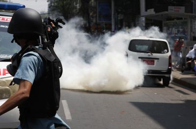 缅甸仰光，一名记者在一次抗议活动中拍摄防暴警察向示威者发射催泪瓦斯。©欧新社-埃菲通讯社