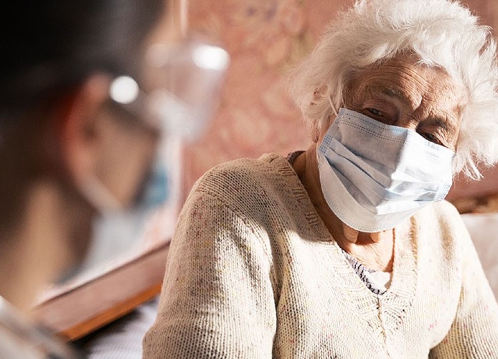 一名医护工作人员正在协助一位老年妇女。©盖蒂图像