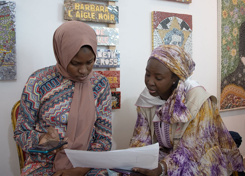 Coumba Fall Ven et Ramatoulaye Basse consultent un rapport envoyé par un observateur dans la salle d’observation de la plateforme Ëtu Jamm. Bureau régional du HCDH pour l’Afrique de l’Ouest – Habibou Dia