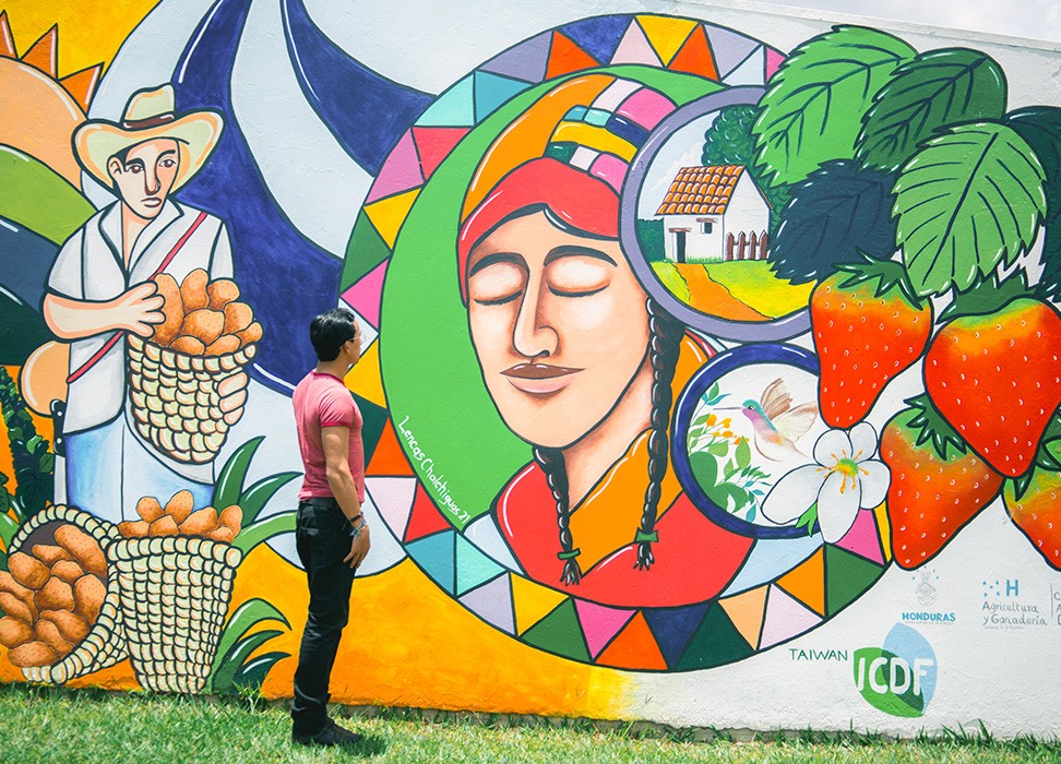 Diego Osorto devant sa peinture murale représentant le peuple autochtone lenca à La Esperanza, dans le département d’Intibucá, au Honduras © HCDH Honduras