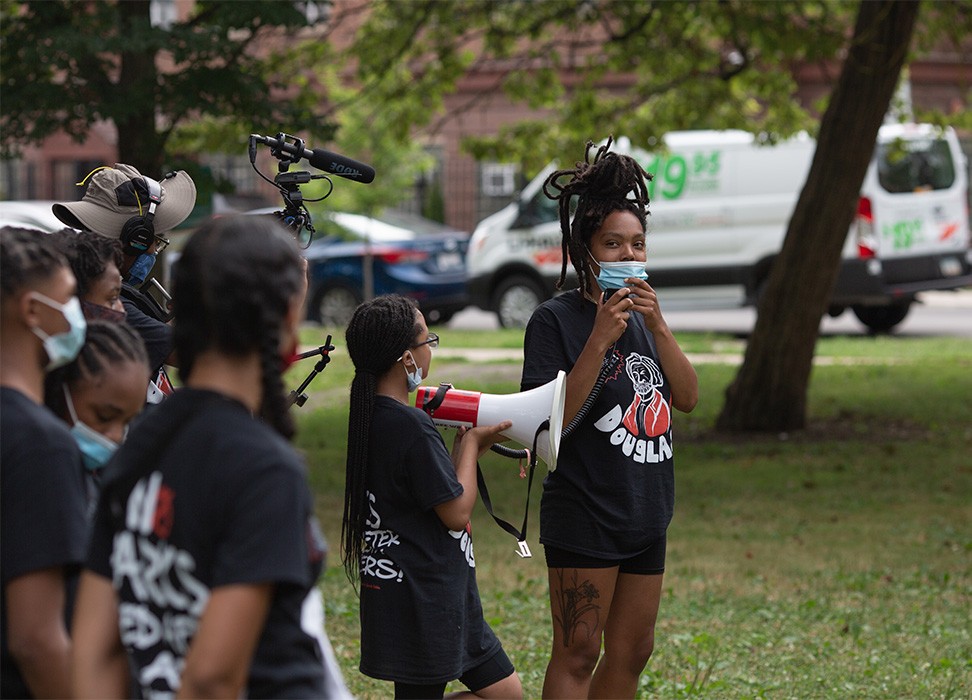 Still of Bianca Jones as she stands alongside youth organizers in Douglass Park addressing a crowd who has come to show support for the park renaming at their Campaign Relaunch Rally on July 18, 2020. © Kaleb Autman 