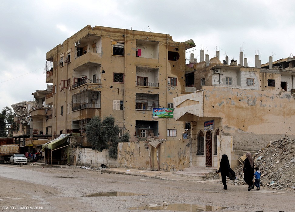 2019年3月31日，叙利亚拉卡市中心，两名叙利亚妇女走过被毁的建筑。©欧新社-埃菲通讯社/AHMED MARDNLI
