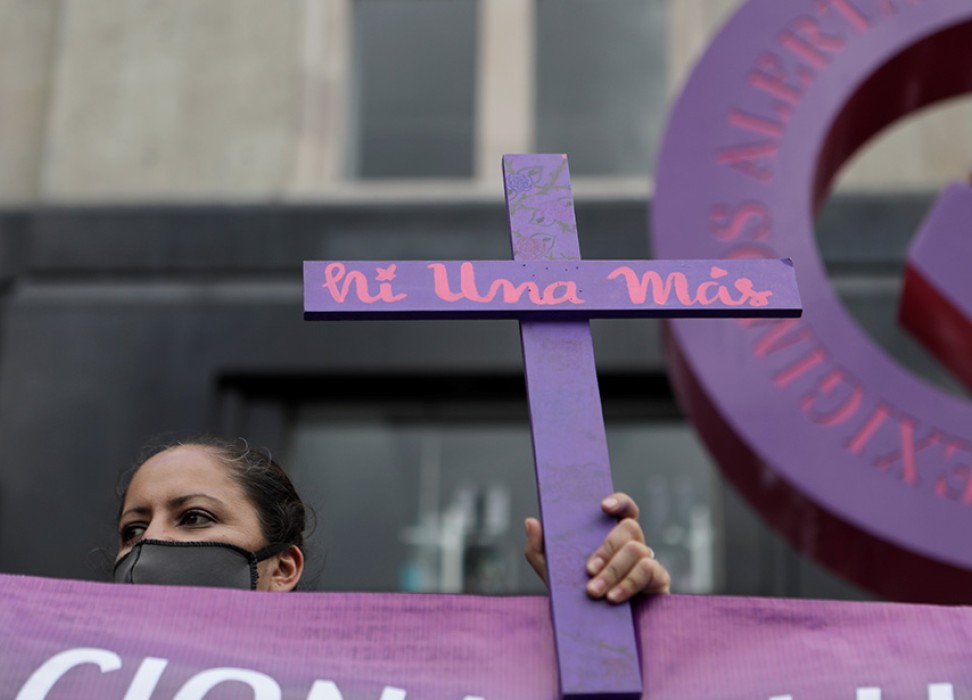 一名女性参加了墨西哥首都墨西哥城的游行活动，她手举写着“不再失踪”的十字架，要求为性别暴力和杀害女性行为的受害者伸张正义。© 路透社／Raquel Cunha