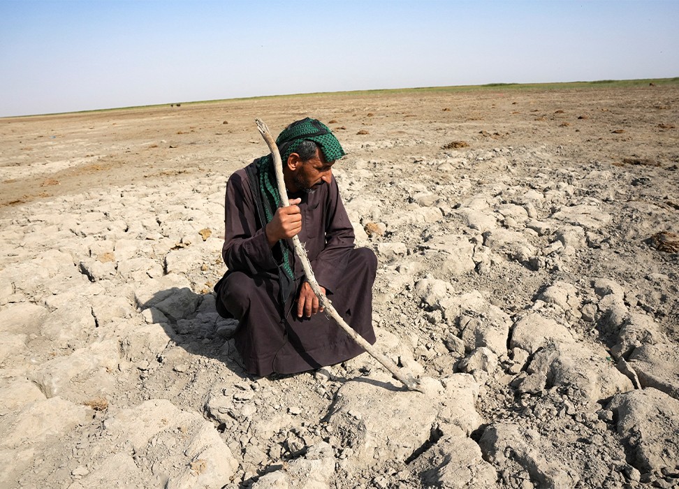 Мужчина из числа болотных арабов смотрит на сухую землю, которая была под водой, около Чибайиша в южном Ираке © REUTERS