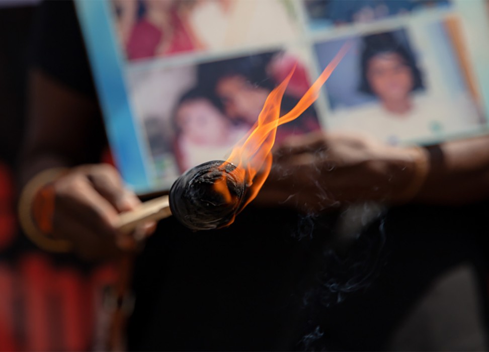 Relatives of the disappeared hold pictures of loved ones during a demonstration. © – Kumanan Kanapathippillai