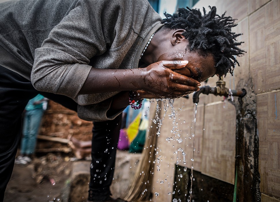 A man washes his face with tap water at a water collection point in Kibera slum, Nairobi, Kenya, 21 March 2018. © EPA-EFE/DAI KUROKAWA