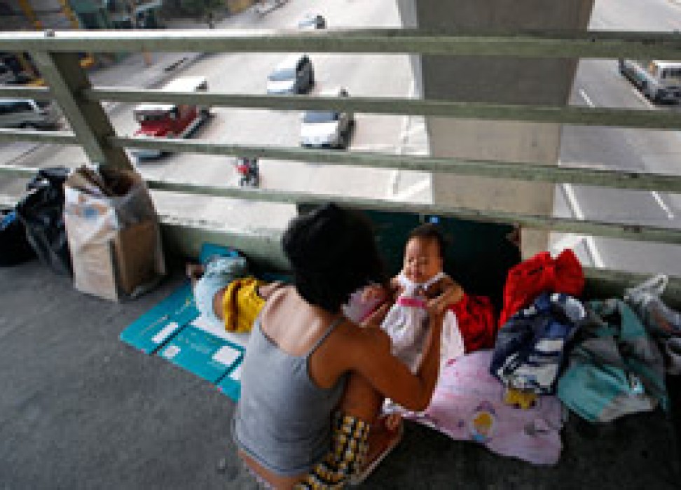 菲律宾母亲在菲律宾马尼拉东部奎松市的天桥上捧着她的女儿，2014年4月9日 © EPA/RITCHIE B. TONGO