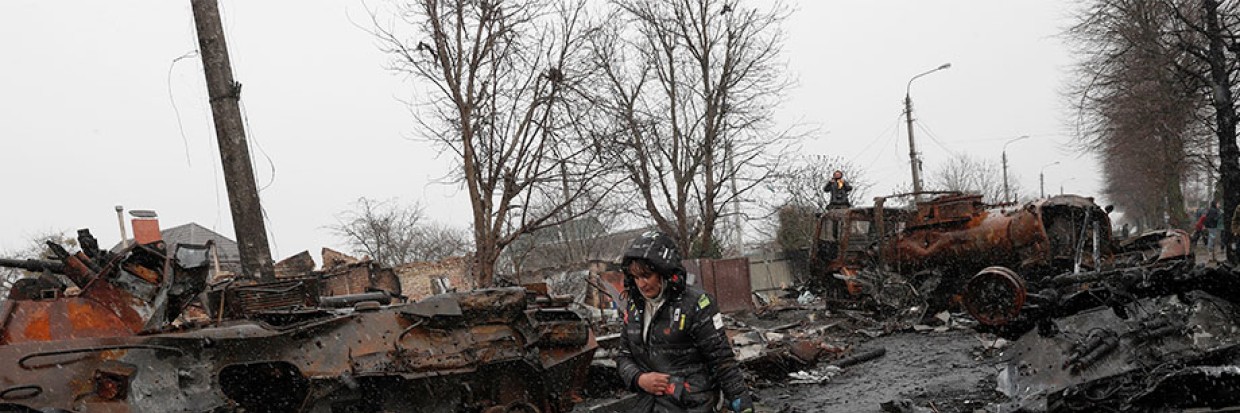 2022年4月3日，在乌克兰布卡市被乌军夺回的地区，一名乌克兰妇女走过被摧毁的俄罗斯军事机器。欧新社-埃菲通讯社／ATEF SAFADI
