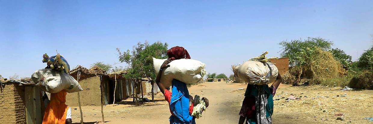 Internally displaced Sudanese women carry bags of farm products on their heads as they walk within the Kalma camp for internally displaced persons (IDPs) in Darfur, Sudan April 25, 2019. 