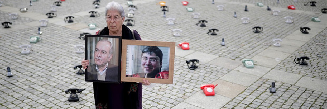 2021年8月28日，在德国柏林，法德瓦·马哈穆德（Fadwa Mahmoud）举着儿子和丈夫的肖像，他们于2012年失踪。多个叙利亚家庭在倍倍尔广场上放置了大约300部固定电话站，以此呼吁各国政府采取更多行动，寻找有关叙利亚被拘留者的下落。路透社／汉尼拔·汉施克（Hannibal Hanschke）