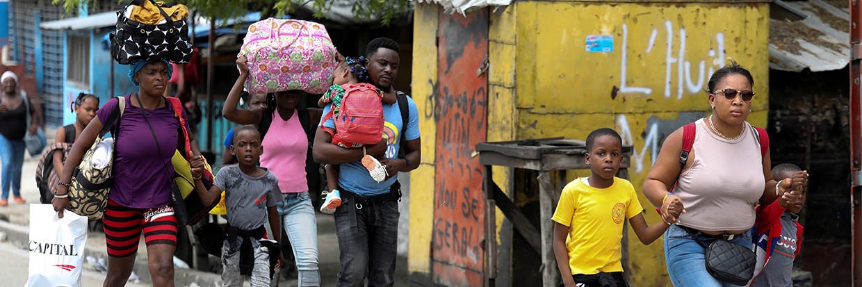 Residents carry their belongings as they flee their homes due to ongoing gun battles between rival gangs, in Port-au-Prince, Haiti May 2, 2022 © REUTERS/Ralph Tedy Erol