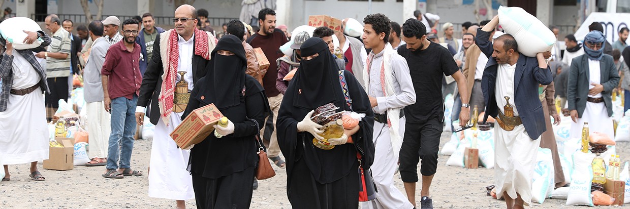 Unas personas llevan los alimentos que han recibido de la organización benéfica local Mona Relief, en Sanaa, Yemen, el 24 de abril de 2022. REUTERS/Khaled Abdullah