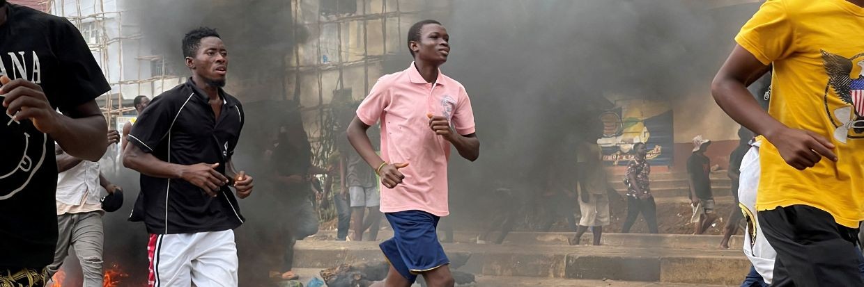 Des personnes s'enfuient pendant une manifestation anti-gouvernementale, à Freetown, en Sierra Leone, le 10 août 2022
