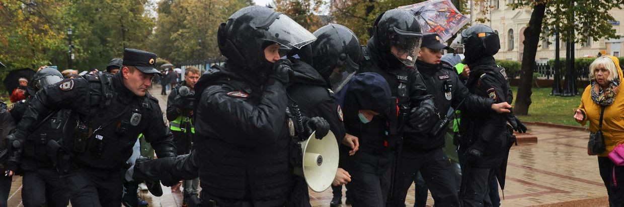 عناصر مكلفون بإنفاذ القانون في روسيا يعتقلون شخصًا خلال مسيرة في موسكو، روسيا في 24 أيلول/ سبتمبر 2022 © رويترز