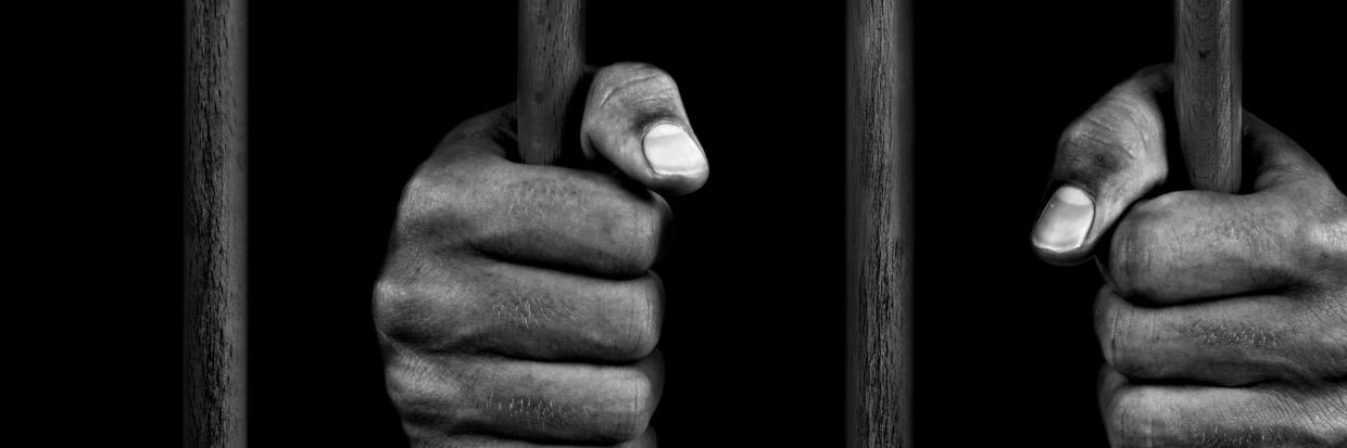 يدا سجين خلف القضبان. © صور غيتي