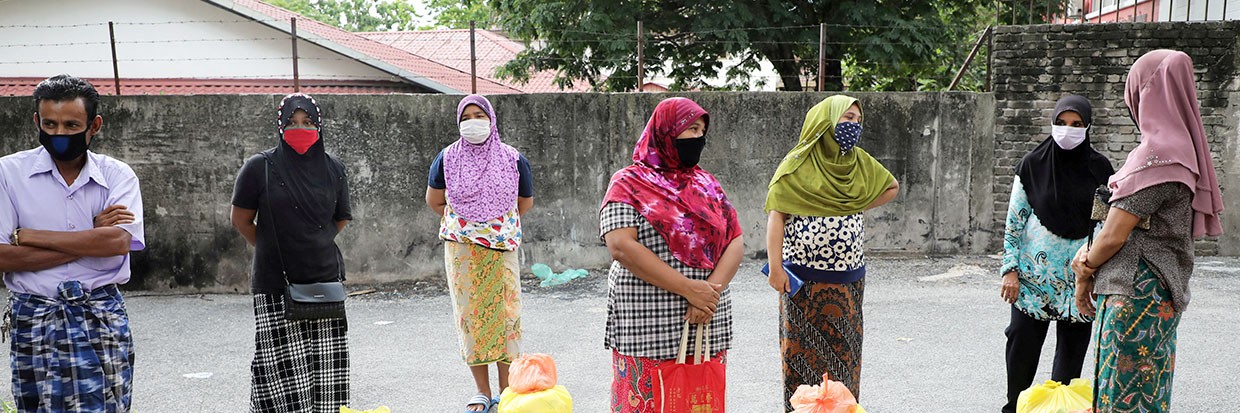 2020年4月7日，马来西亚吉隆坡，在因冠状病毒病（2019冠状病毒病）爆发颁布封城令期间，罗辛亚难民在等待志愿者发放货品时戴着防护口罩，并保持一定的社交距离。©路透社/Lim Huey Teng/档案照片/档案照片