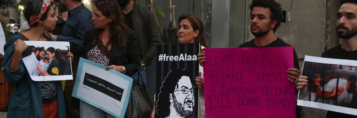 Demonstrators hold signs as they demand the release of Egyptian-British hunger striker Alaa Abd el-Fattah near the British Embassy in Beirut, Lebanon November 7, 2022. © Reuters