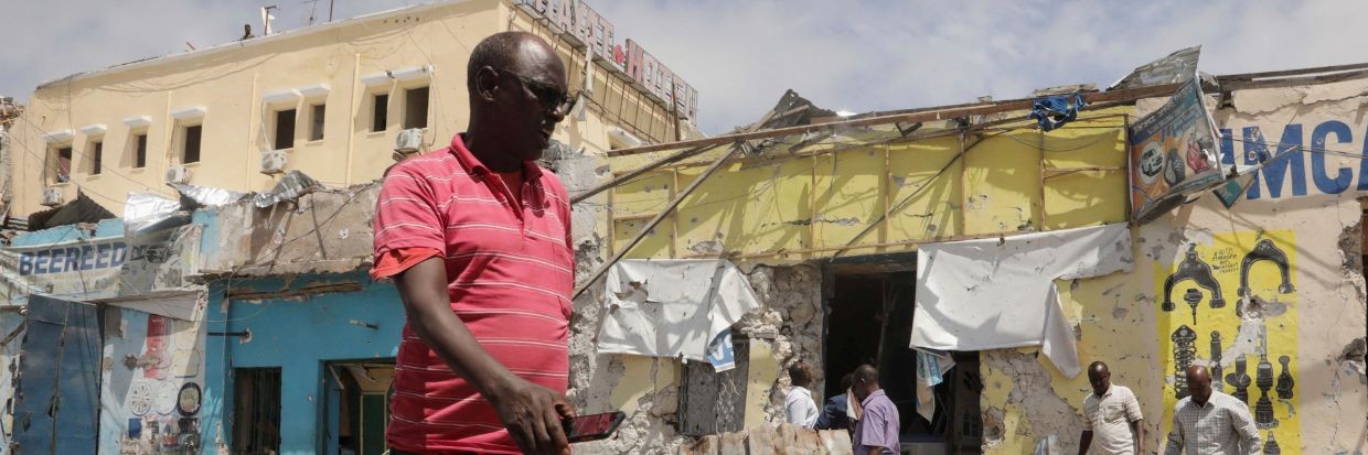 عدد من السكان ينظرون إلى موقع الاعتداء الذي نفّذته جماعة الشباب المرتبطة بتنظيم القاعدة في مقديشو بالصومال، 21 أغسطس/ آب 2022 Ⓒ رويترز