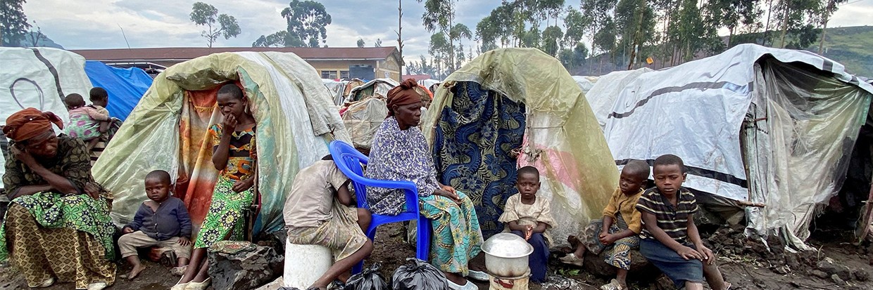 Paskazia Kimanuka, 58 ans, assise avec ses enfants devant leur abri de fortune dans le camp de déplacés de Kanyaruchinya, près de Goma, dans la province du Nord-Kivu, en République démocratique du Congo, le 22 novembre 2022. © REUTERS/Djaffar Sabiti