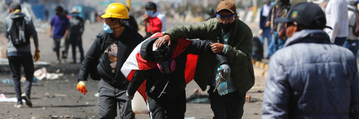 Un manifestante ayuda a un hombre herido durante choques con las fuerzas de seguridad, mientras piden elecciones anticipadas y la liberación del expresidente Pedro Castillo, cerca del aeropuerto de Juliaca, en Perú, el 9 de enero de 2023.  © REUTERS/Hugo Courotto 