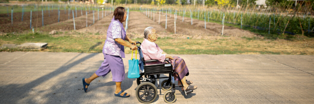 Sampao Jantharun (L), 78, assists Somjit Phuthasiri, 90, on a wheelchair as they head to their home at Wellness Nursing Home Center in Ayutthaya, Thailand, April 9, 2016. Many Thai families look after elderly relatives at a cost that countrywide adds up to just under a third of household income. The number of families facing this issue will balloon as the population ages at a rate among the fastest in Southeast Asia. © Reuters