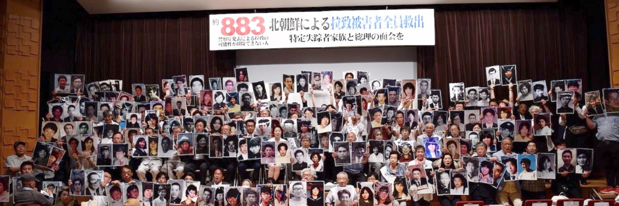 مشاركون في تجمع حاشد نُظم في كوبي يحملون صورًا للمختطفين والمختطفين المحتملين من قبل جمهورية كوريا الشعبية الديمقراطية، آذار/ مارس 2020. © COMJAM