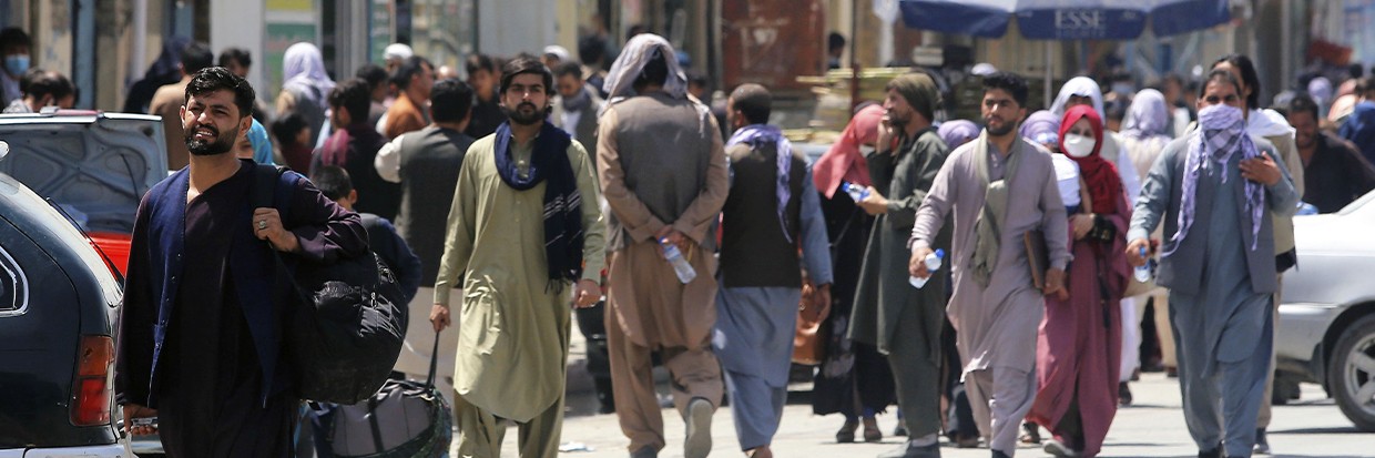 Des personnes se dirigent vers une installation militaire dans un aéroport de Kaboul, le 23 août 2021, après le récent retour au pouvoir du groupe militant islamique des Taliban. © (Kyodo)