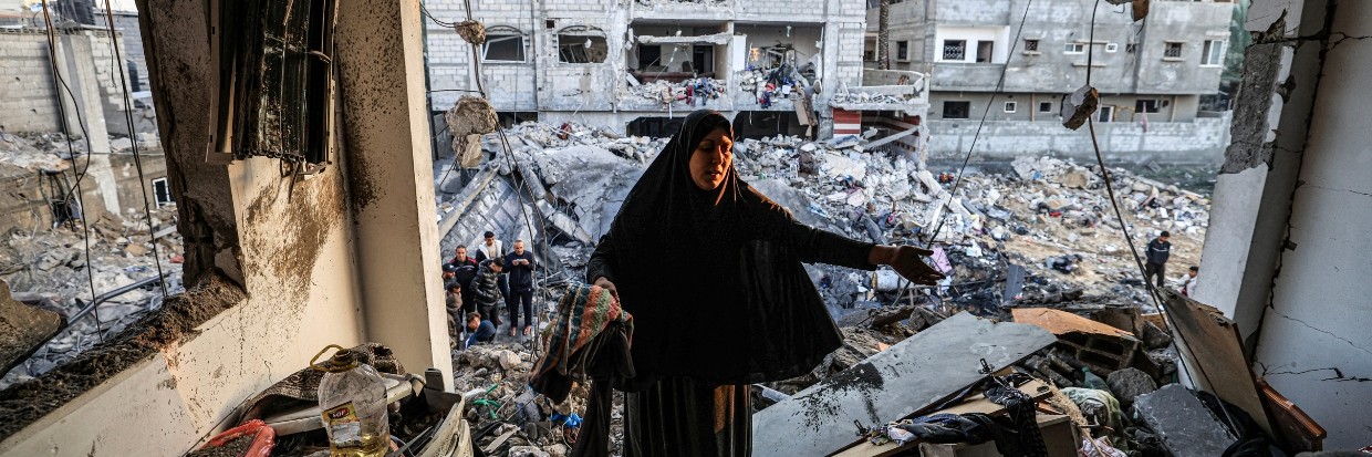 Una mujer inspecciona el edificio destruido del periodista palestino Adel Zorob, quien falleció durante la noche en un bombardeo israelí en Rafah, al sur de la Franja de Gaza, 19 de diciembre de 2023. © Mahmud HAMS / AFP