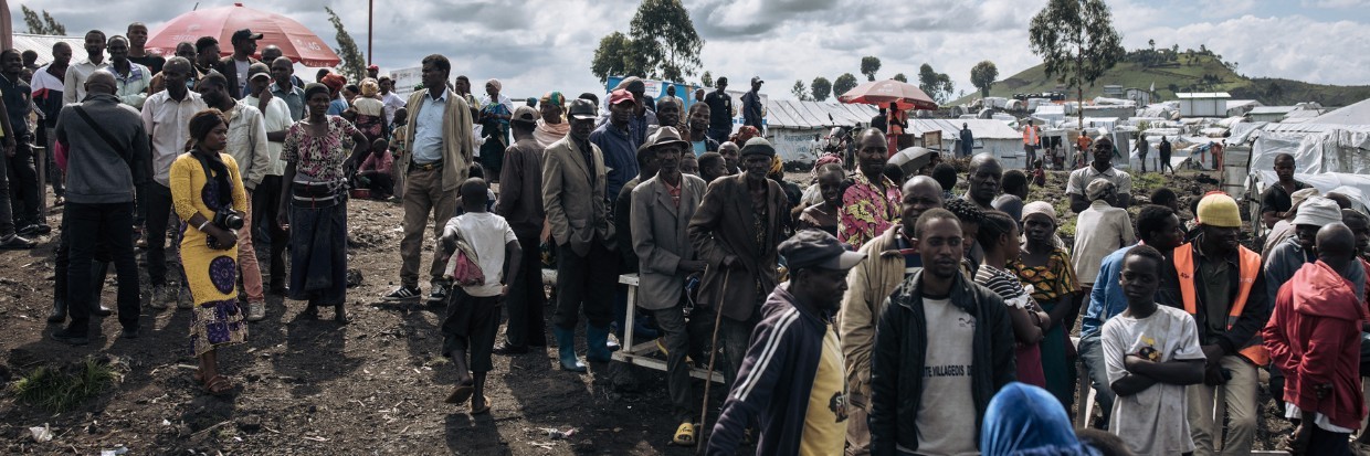 War-displaced people gather to watch a delegation of UN officials visiting the Bulengo IDP camp, near a front line on the western outskirts of Goma, on April 17, 2024. 