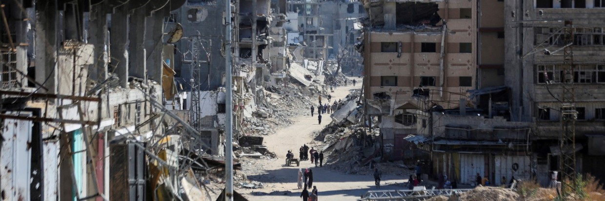 Palestinians make their way in a devasted neighborhood, amid the ongoing Israel-Hamas conflict, in Gaza City, October 24, 2024. 