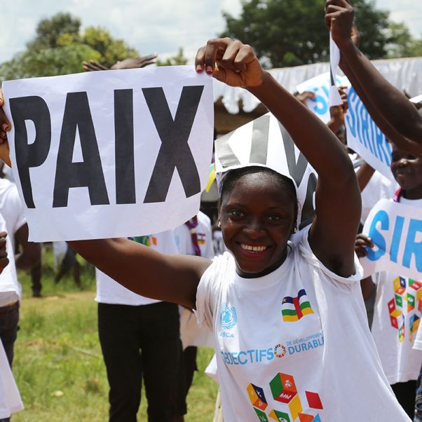 Девочка держит плакат с надписью "Мир"