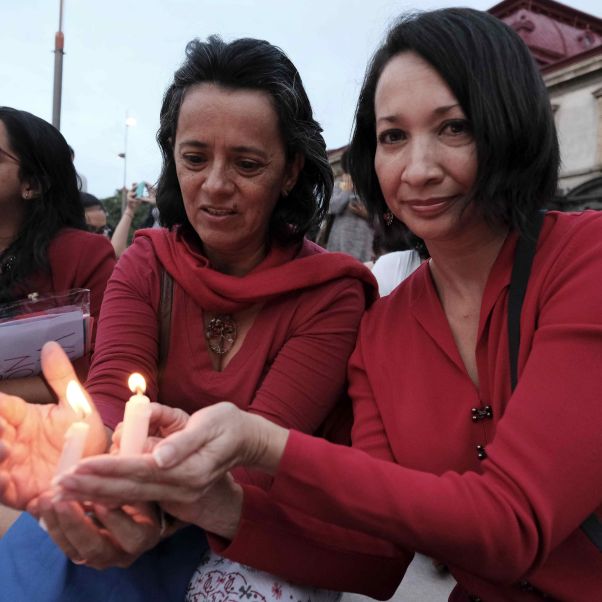 Две женщины держат свечу