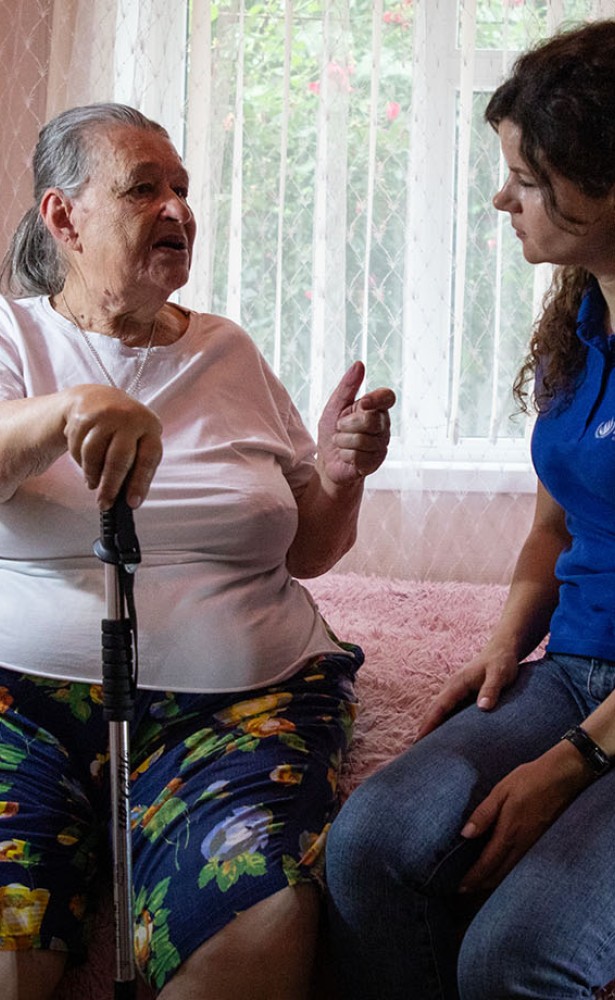 Liubov, a refugee from Ukraine, talks to a UN Human Rights officer in her home in Moldova.