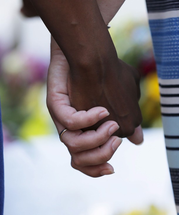 Mourners hold hands outside the Emanuel African Methodist Episcopal Church in Charleston, South Carolina, June 18, 2015 a day after a mass shooting left nine dead. © REUTERS/Brian Snyder