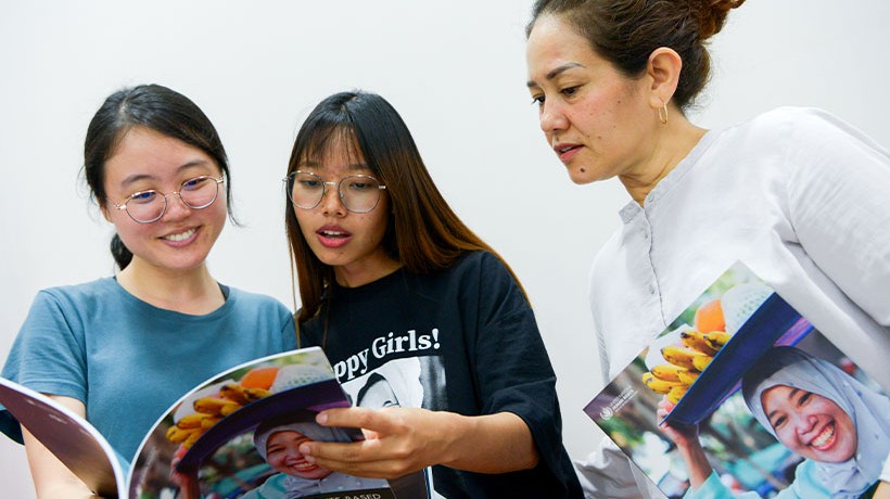 Participants took turns to look at the first copies of an innovative guide: "Building Human Rights-Based Migration Narratives: The Story of Dari Dapur and MyGreat Story.”  © Dari Dapur