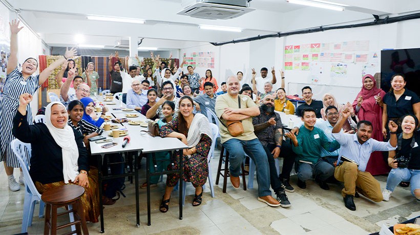 Refugees, migrants, Malaysians, and High Commissioner Türk and his team posed for a group photo at the end of the potluck event. © Dari Dapur