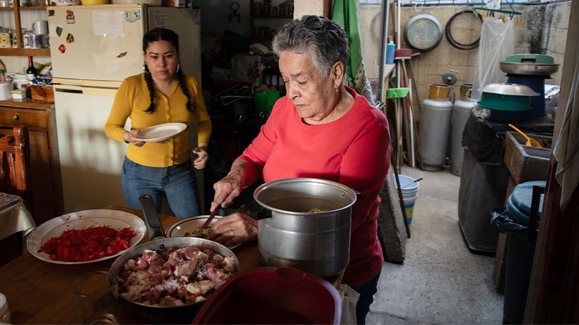 Two women cook. 